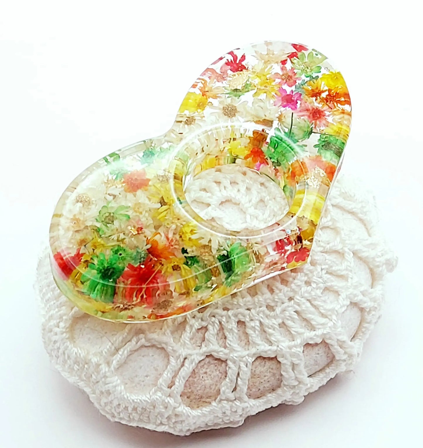 Bague de lecture Coeur en résine, fleurs multicolores, posée sur un galet