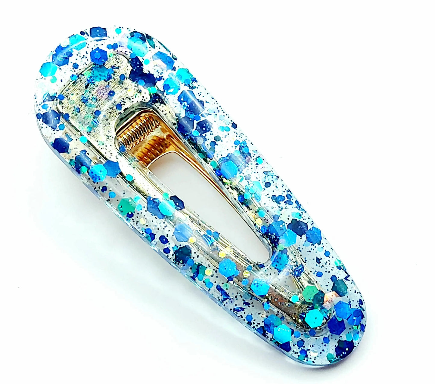 Barrette à cheveux arrondie en résine époxy. Transparente et paillettes bleues.