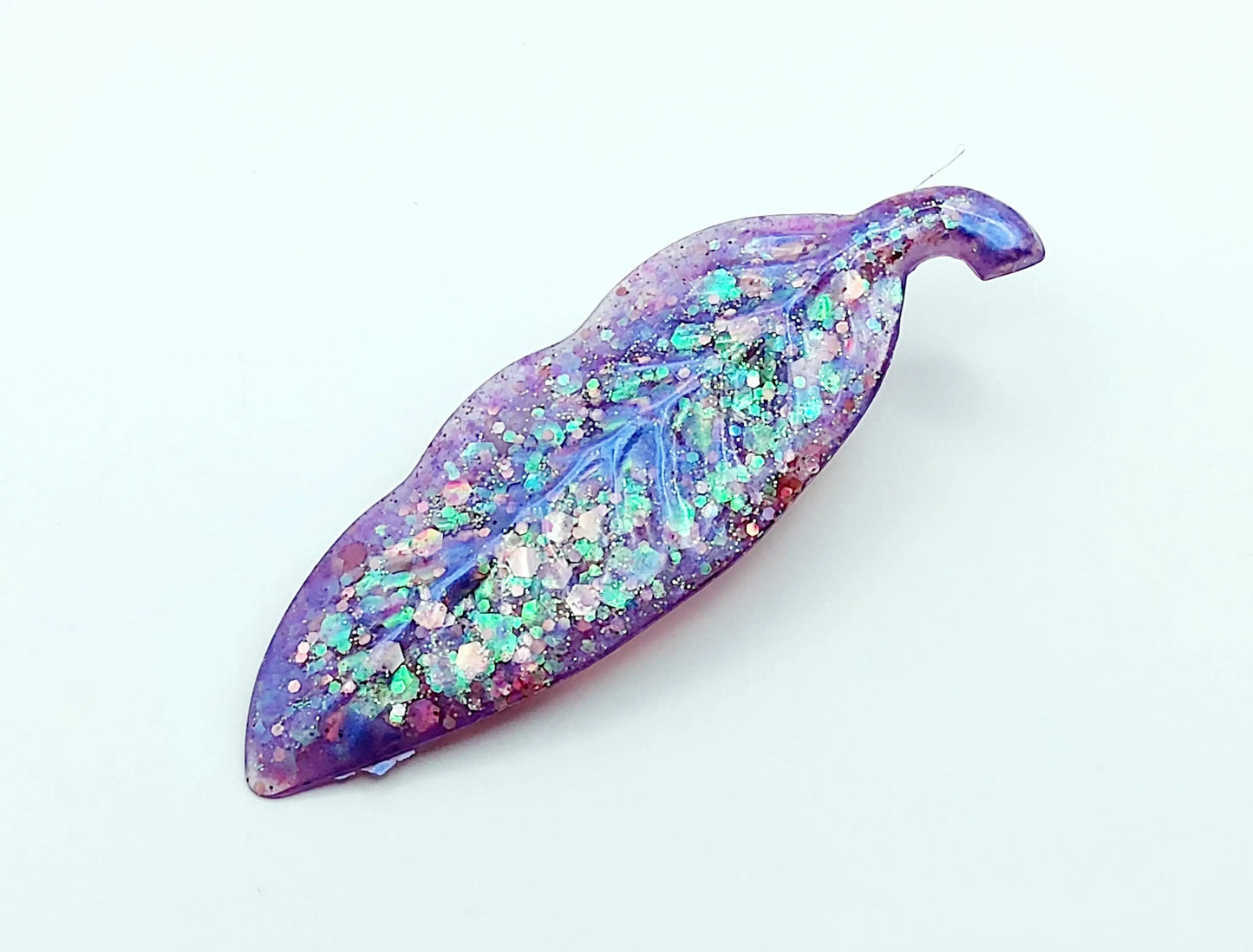 Barrettes à cheveux "Feuille" en résine époxy, paillettes holographiques mauves. Gros plan.