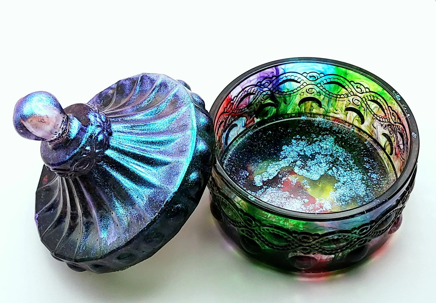 Boîte de rangement "Baroque" en résine époxy, multicolore et irisée. Couvercle posé de travers sur la boîte à gauche. Vue de dessus.