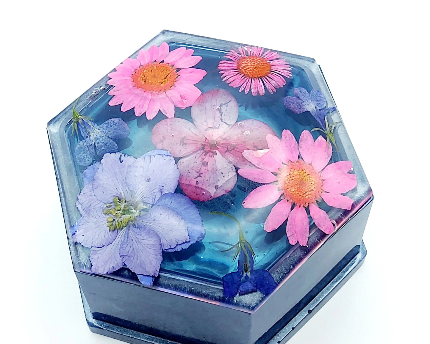 Boîte de rangement "Hexagone" en résine époxy. bleu et fleurs séchées naturelles roses et mauves. Fermée, vue de dessus.