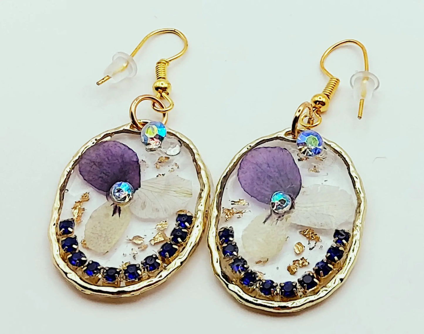Boucles d'oreilles "Fleurs et strass", en résine. Fleurs de pensées et strass bleus. Forme ovale