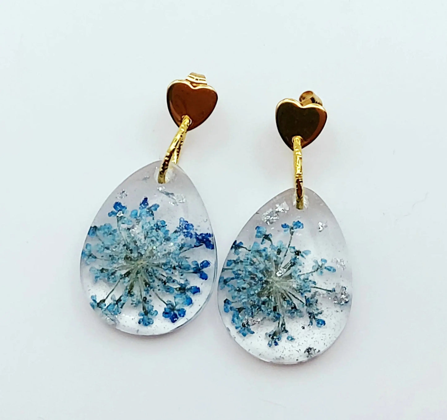 Boucles d'oreilles en résine "Fleur bleue dans une goutte d'eau", avec feuille d'argent, apprêts en forme de coeur, vue de face