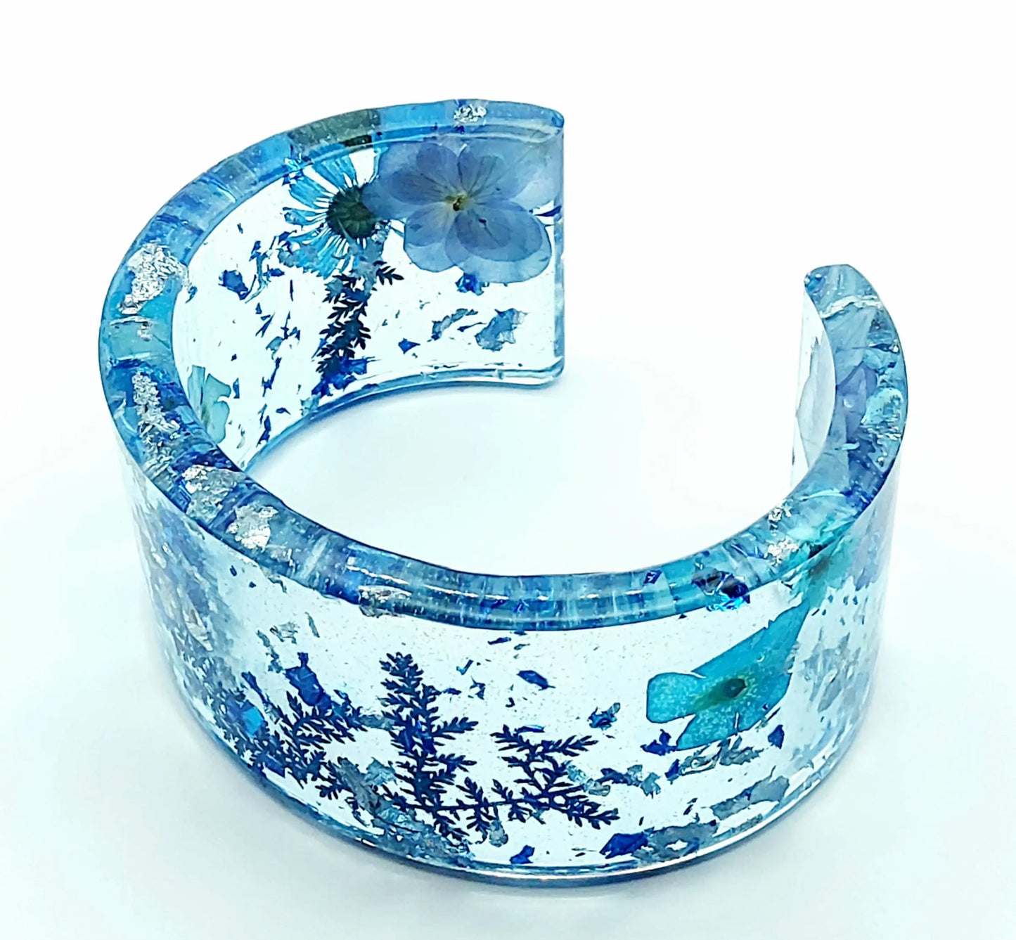 Bracelet manchette en résine époxy. Fleurs bleues et feuille d'argent.