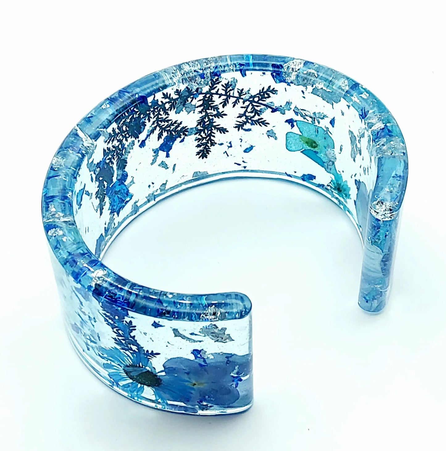 Bracelet manchette en résine époxy. Fleurs bleues et feuille d'argent.