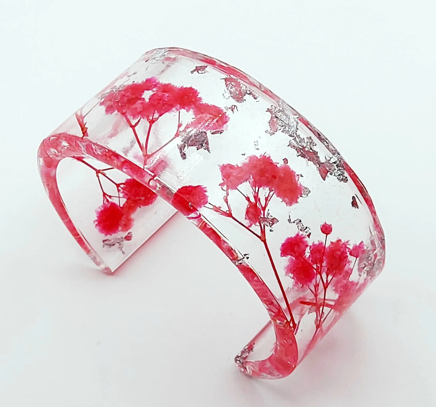 Manchette en résine époxy. Fleurs fuchsia et feuille d'argent.