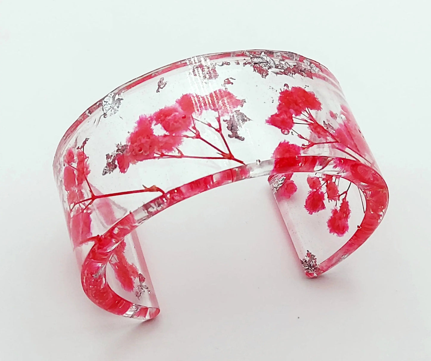 Manchette en résine époxy. Fleurs fuchsia et feuille d'argent.
