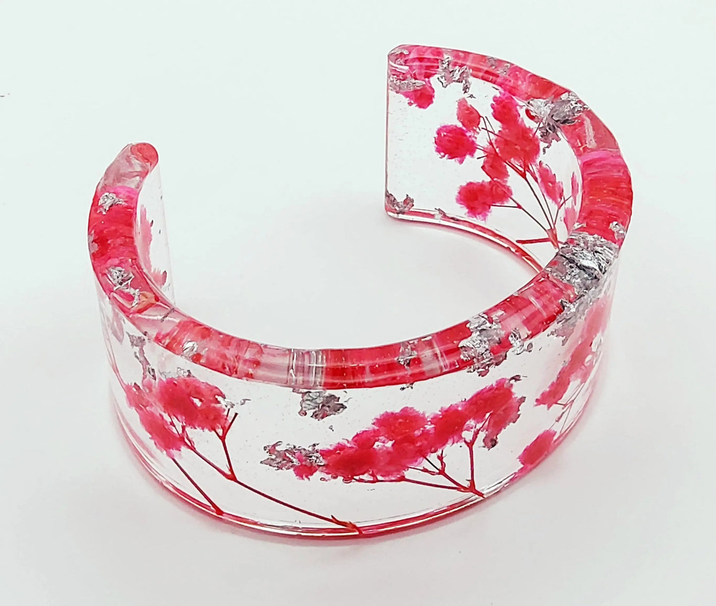 Manchette en résine époxy. Fleurs fuchsia et feuille d'argent.