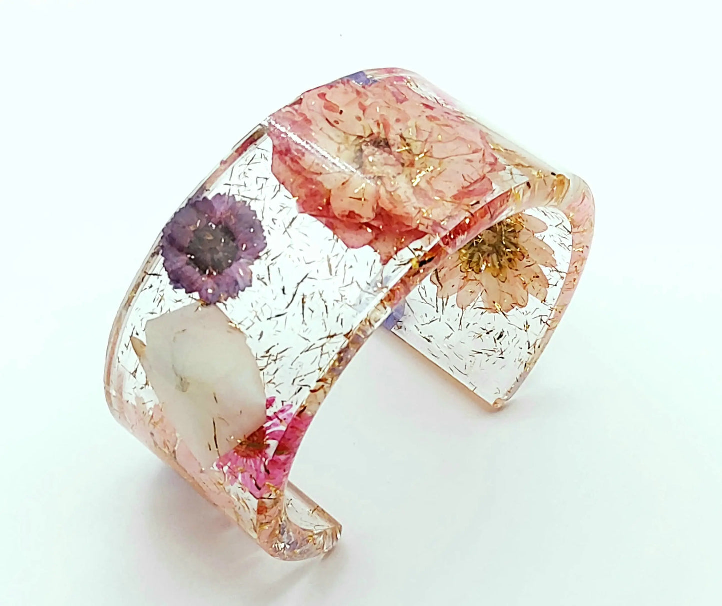Manchette en résine époxy. Fleurs roses, violettes, blanches et bleues. Paillettes or.