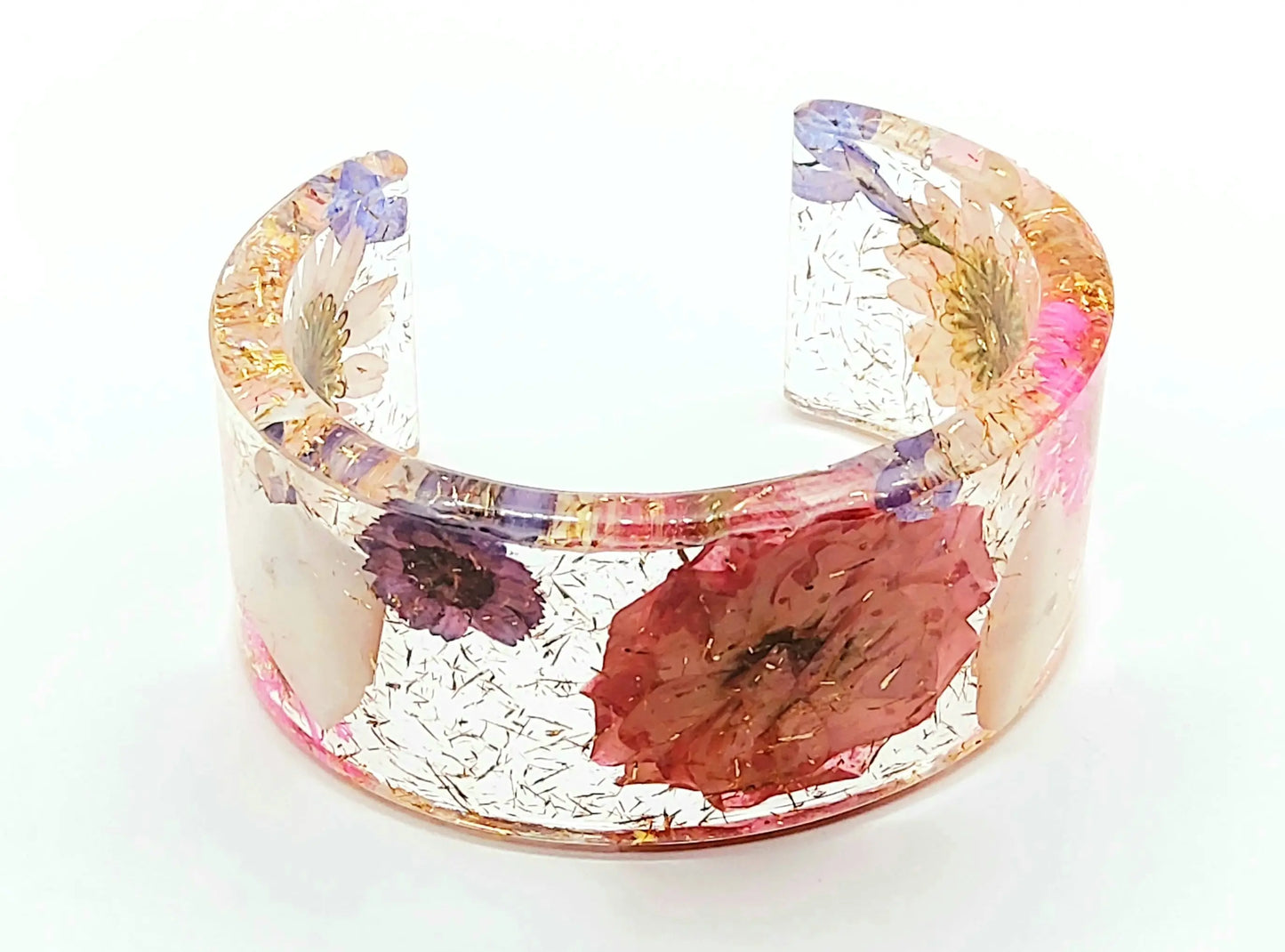 Manchette en résine époxy. Fleurs roses, violettes, blanches et bleues. Paillettes or.