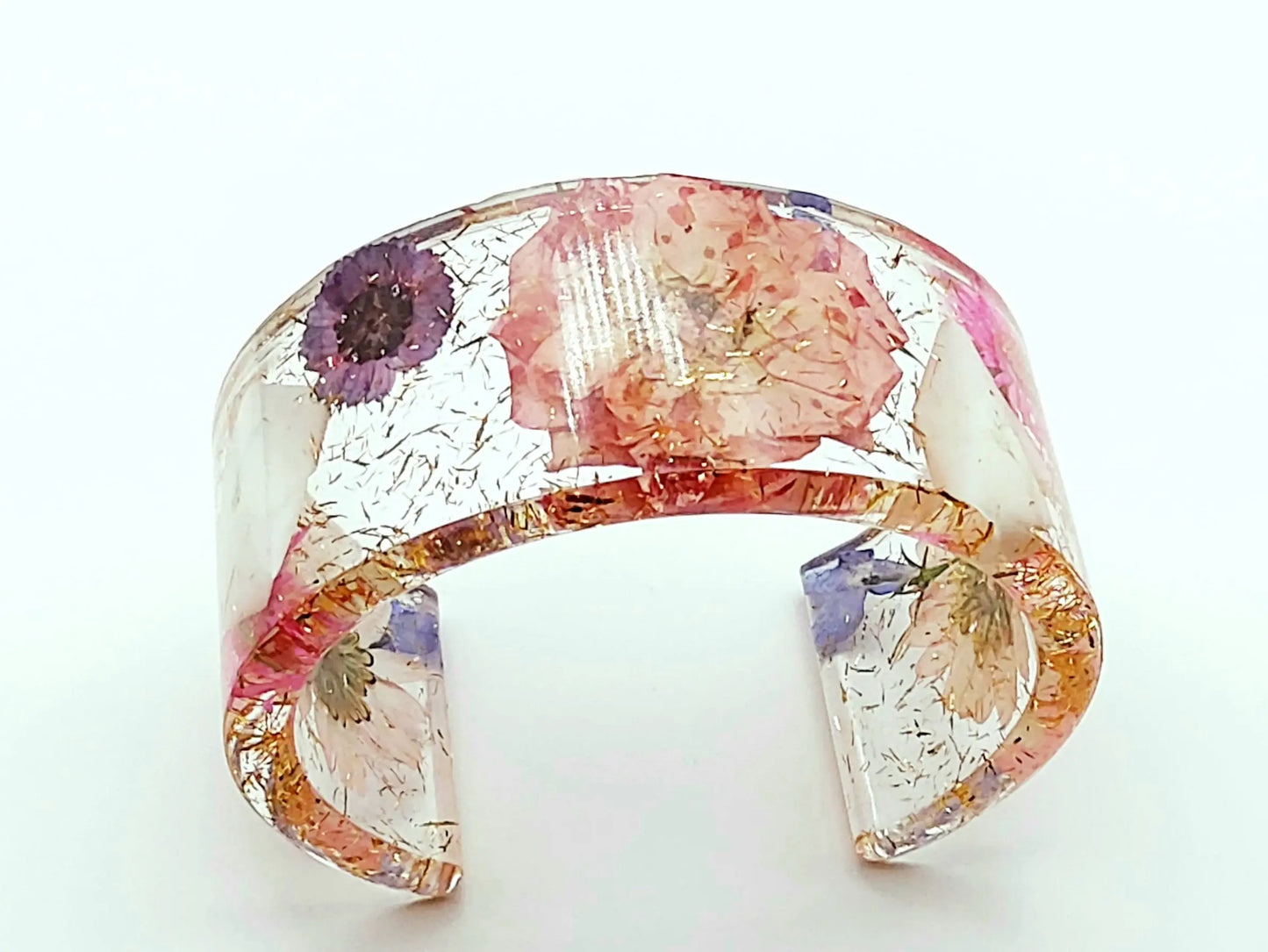 Manchette en résine époxy. Fleurs roses, violettes, blanches et bleues. Paillettes or.