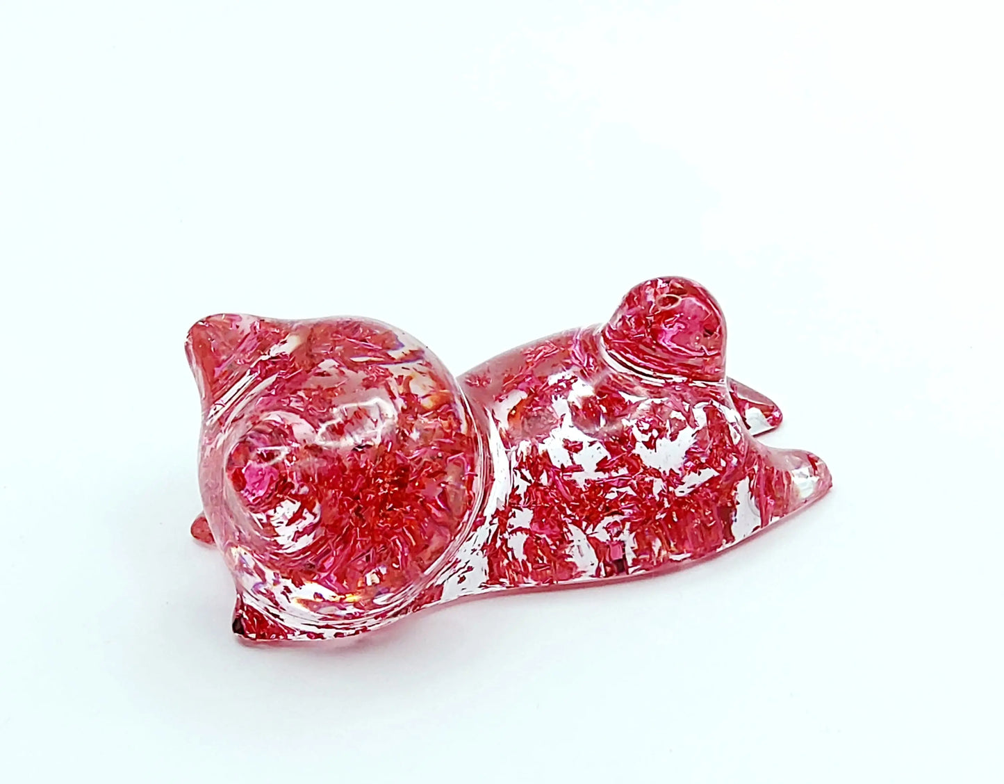 Figurine "Chaton couché" en résine époxy, transparent et feuille rose, gros plan.