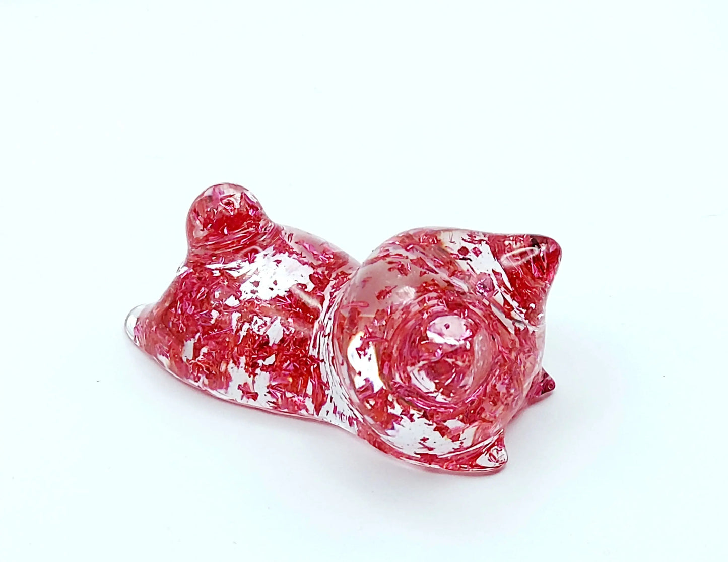 Figurine "Chaton couché" en résine époxy, transparent et feuille rose, gros plan.