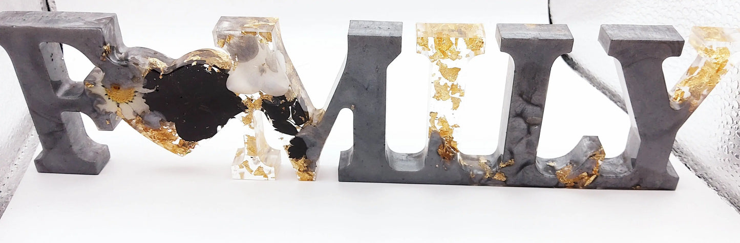 Mot décoratif "FAMILY" en résine époxy. Gris argenté, fleurs noires et blanches. Feuille d'or.