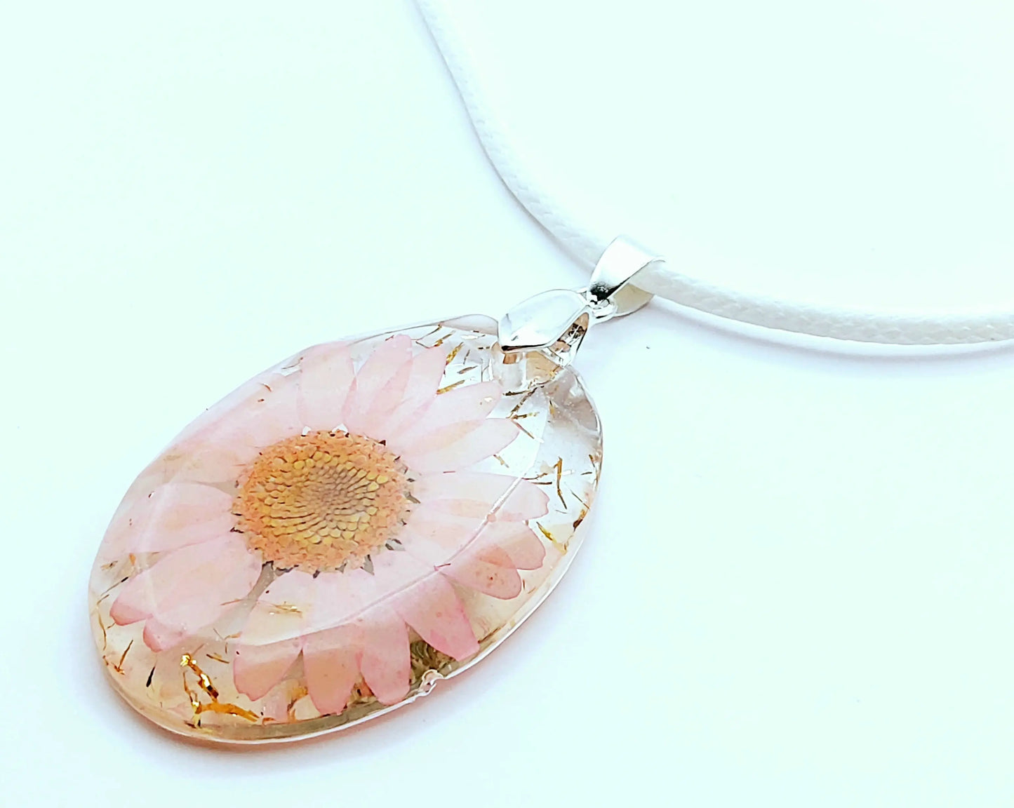 Pendentif OVALE en résine époxy. Fleur rose et paillettes dorées. Cordon en coton ciré blanc. PRETTY RESINE
