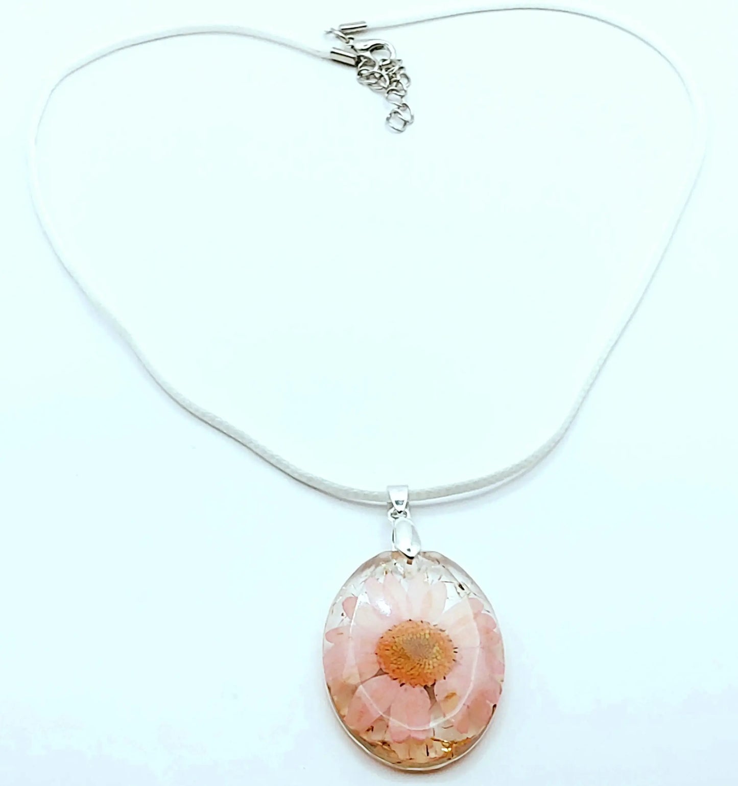 Pendentif OVALE en résine époxy. Fleur rose et paillettes dorées. Cordon en coton ciré blanc. PRETTY RESINE