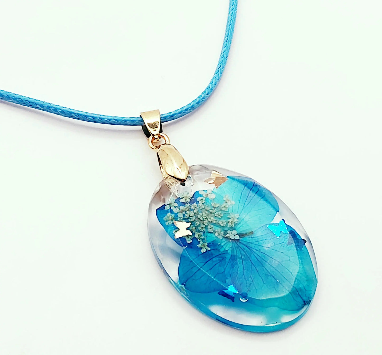 Pendentif OVALE en résine époxy. Fleurs bleue et blanche. Cordon en coton ciré bleu. PRETTY RESINE