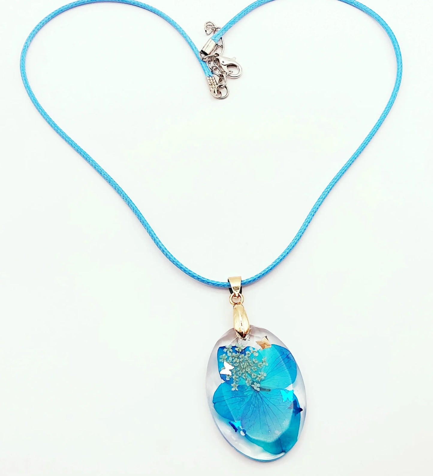 Pendentif OVALE en résine époxy. Fleurs bleue et blanche. Cordon en coton ciré bleu. PRETTY RESINE