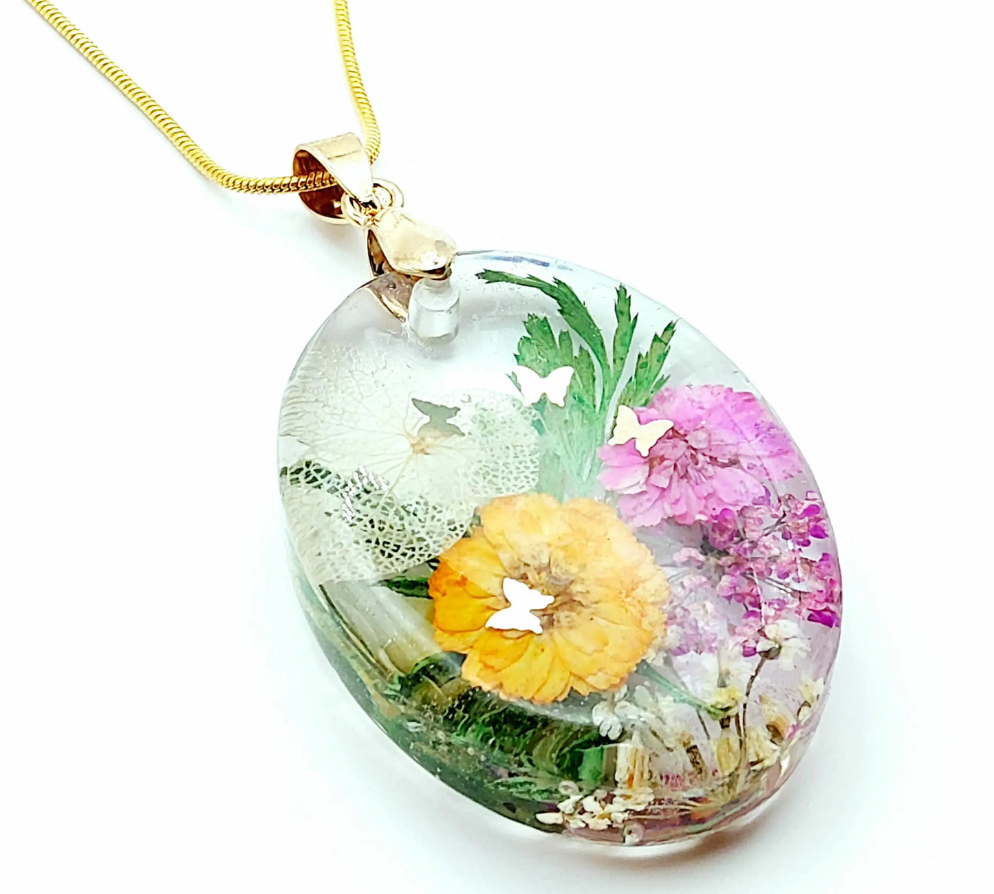 Pendentif Ovale en résine époxy et sa chaîne dorée. Fleurs multicolores et papillons dorés.