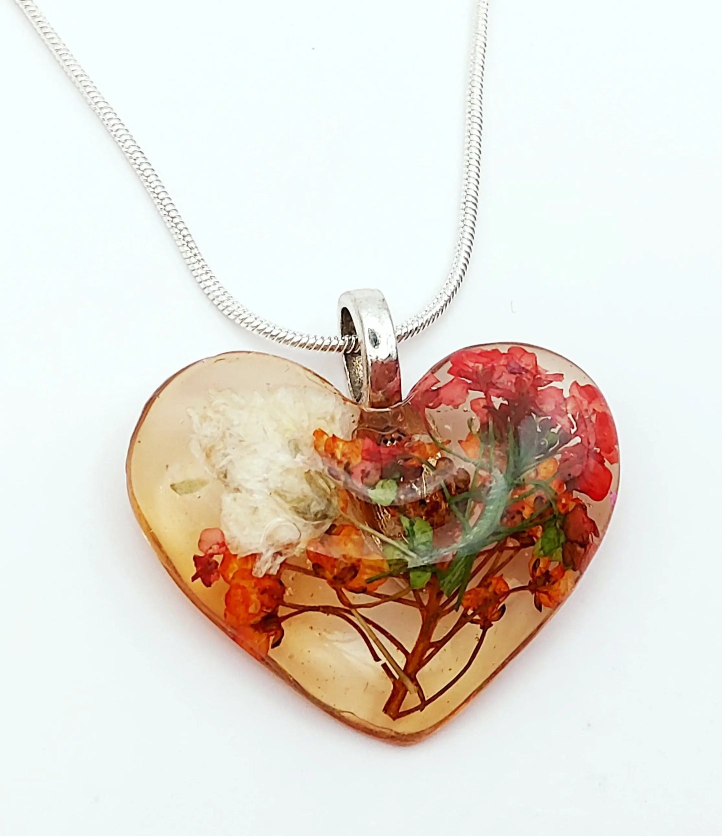 Pendentif "Coeur fleuri" en résine, et sa chaîne. Fleurs rouges, oranges et blanches