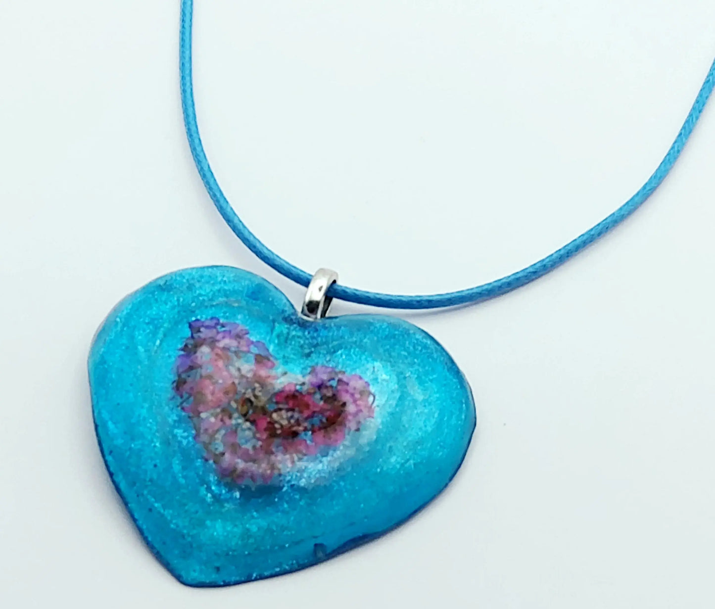 Pendentif "Coeur fleuri" en résine époxy - Bleu avec un insert de fleurs en forme de coeur
