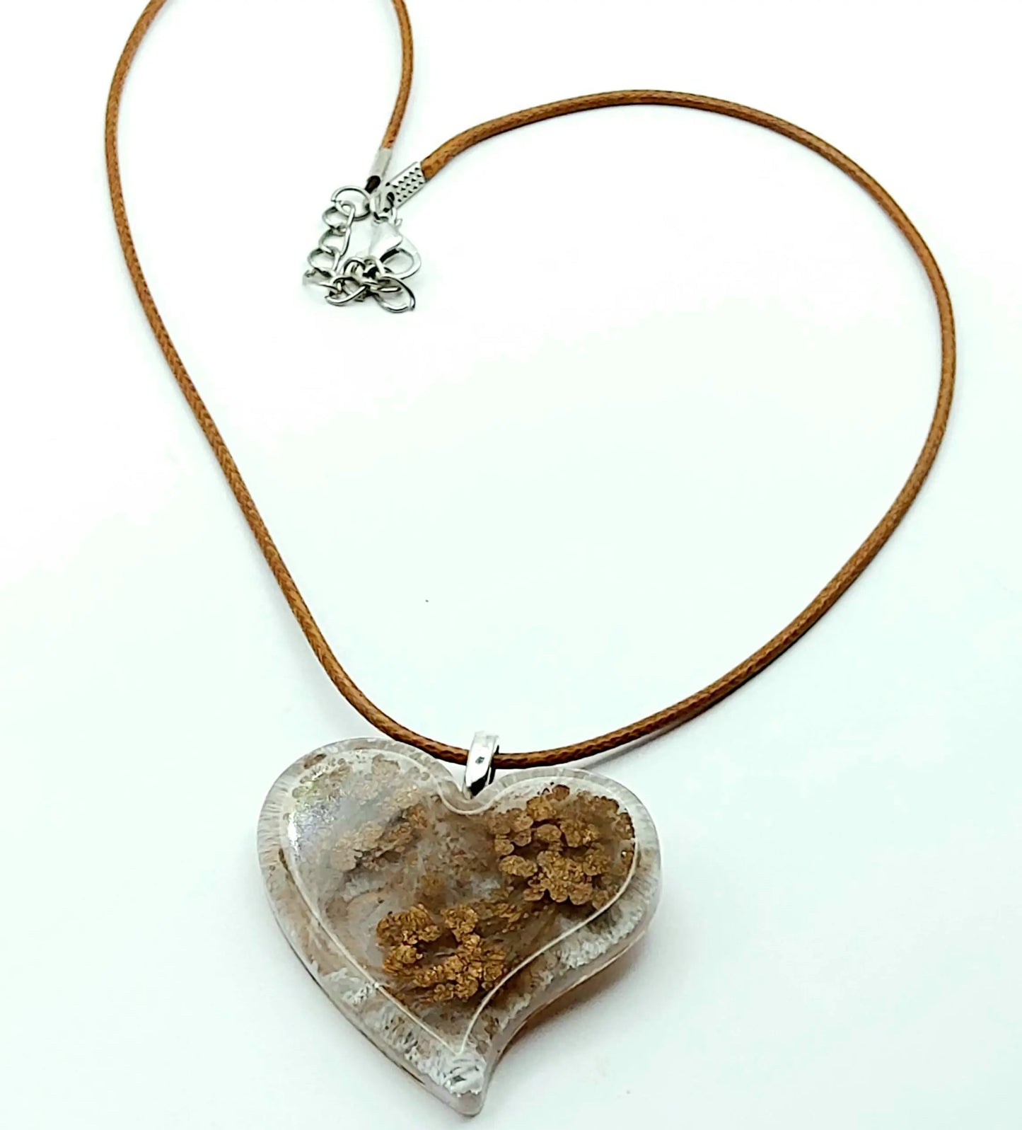 Pendentif "Petit Coeur" en résine époxy, effet pétri marron et crème. Cordon en coton ciré marron. Plan large.