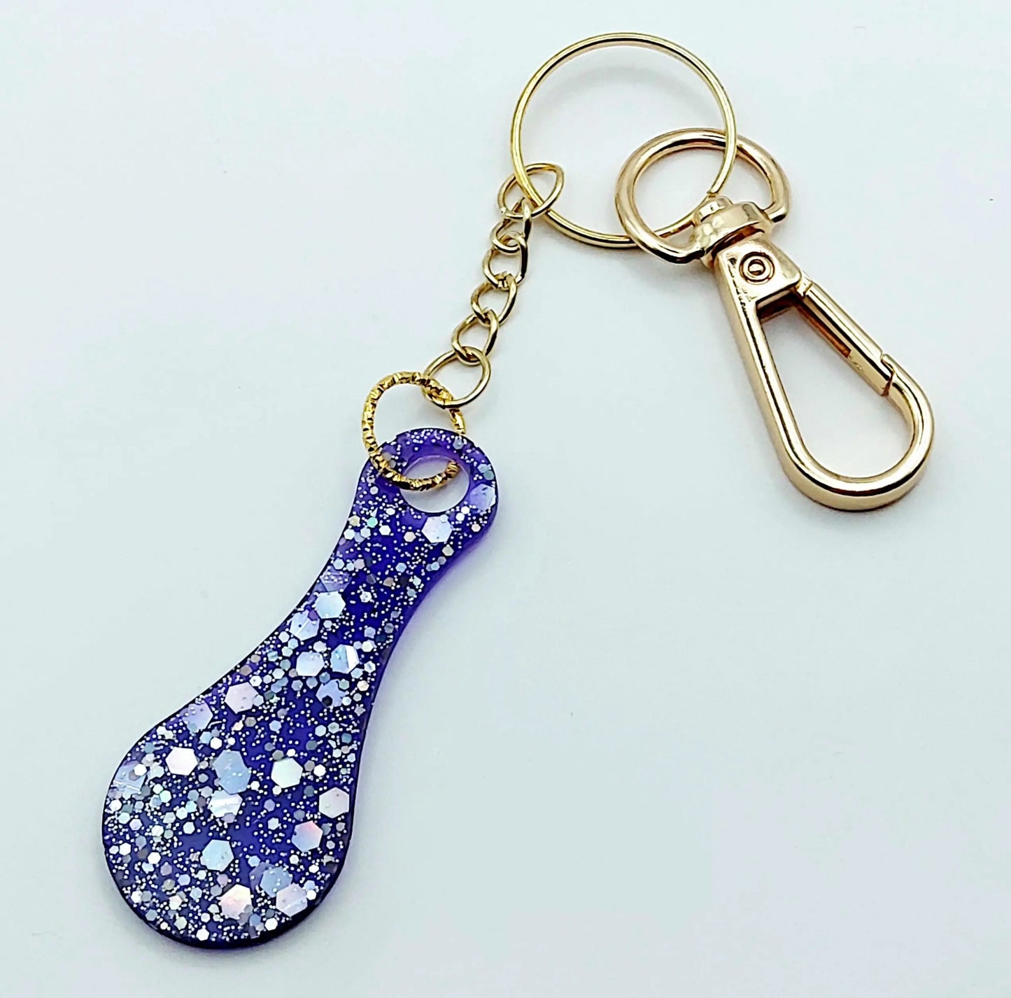 Porte-clés "Jeton de caddie" en résine époxy, violet et paillettes argentées. Anneau et mousqueton dorés.