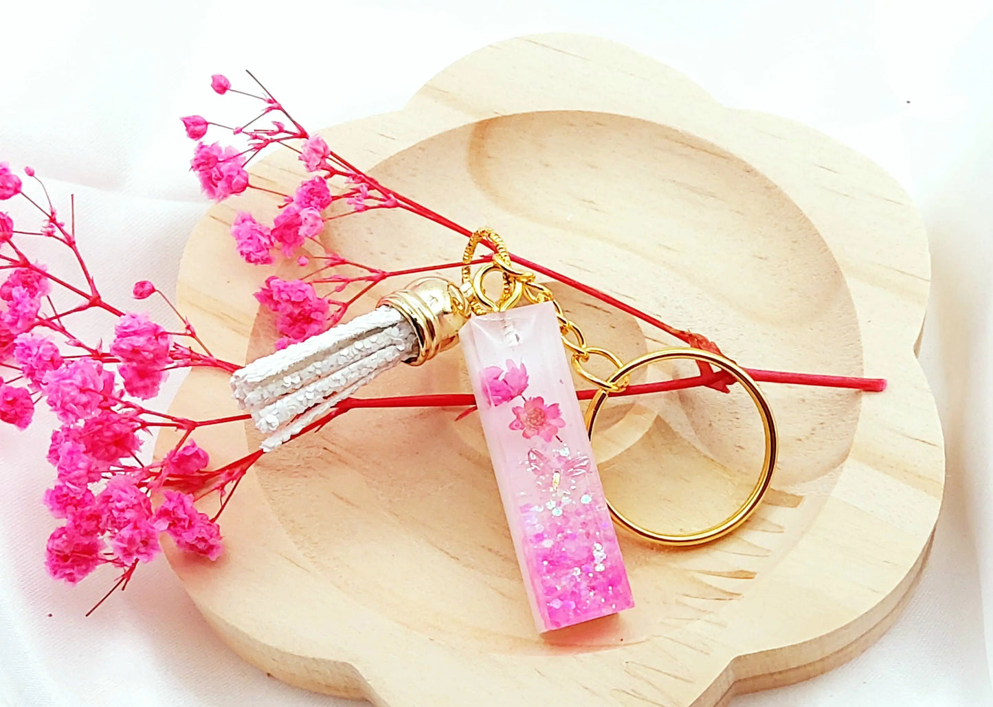 Porte-clés LETTRE I en résine époxy. Fond blanc. Paillettes, fleurs et papillon rose. Pompon gland pailleté blanc - PRETTY RESINE
