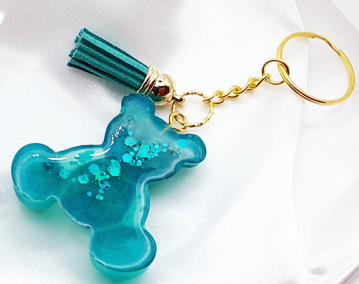 Porte-clés OURSON ASSIS en résine époxy. Vert avec paillettes. Anneau doré. Pompon gland vert. Vue de l'envers