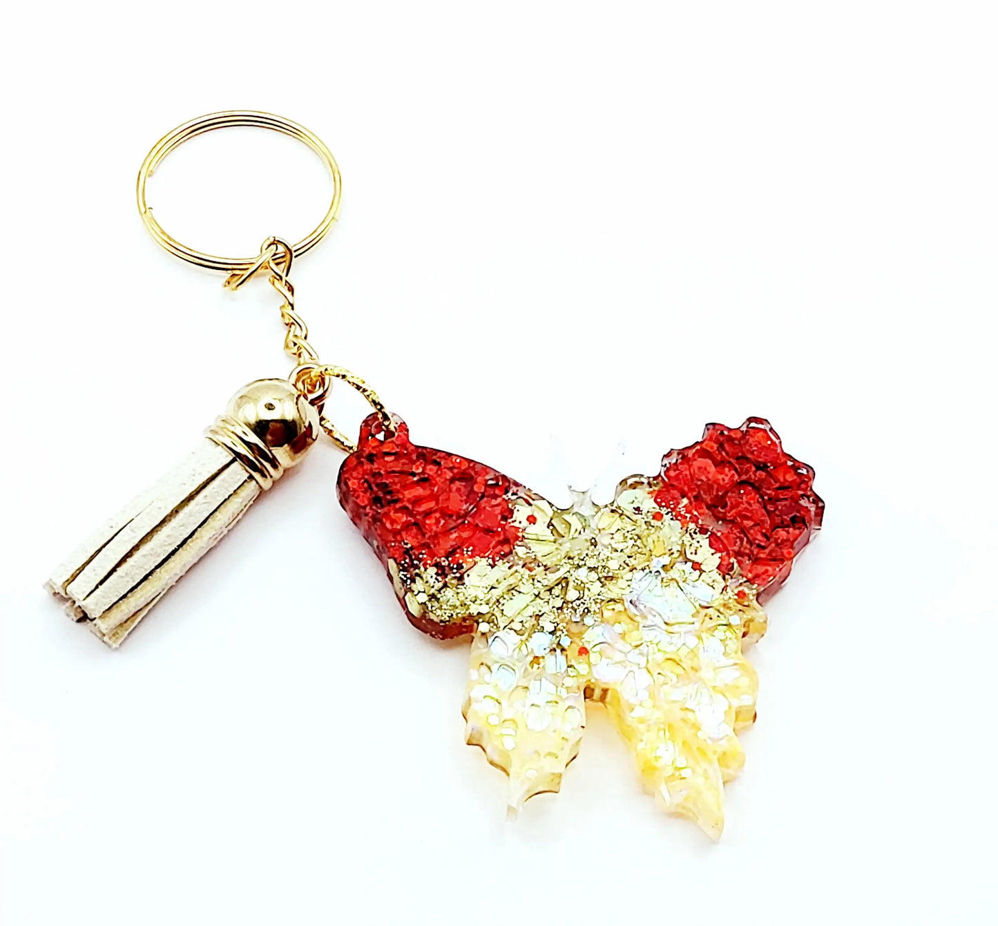 Porte-clés "Papillon" en résine époxy, paillettes rouges et or. Anneau doré, pompon gland beige.
