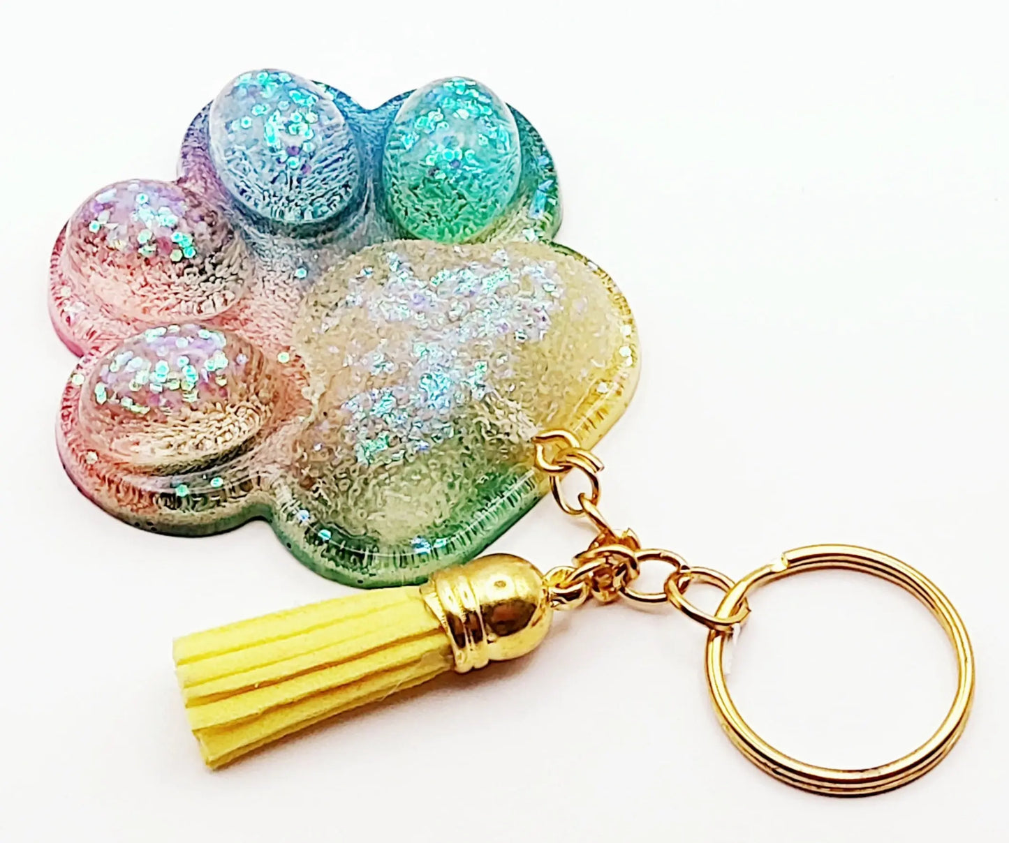 Porte-clés "Patte d'ours" en résine époxy. Multicolore, anneau doré, pompon gland jaune.