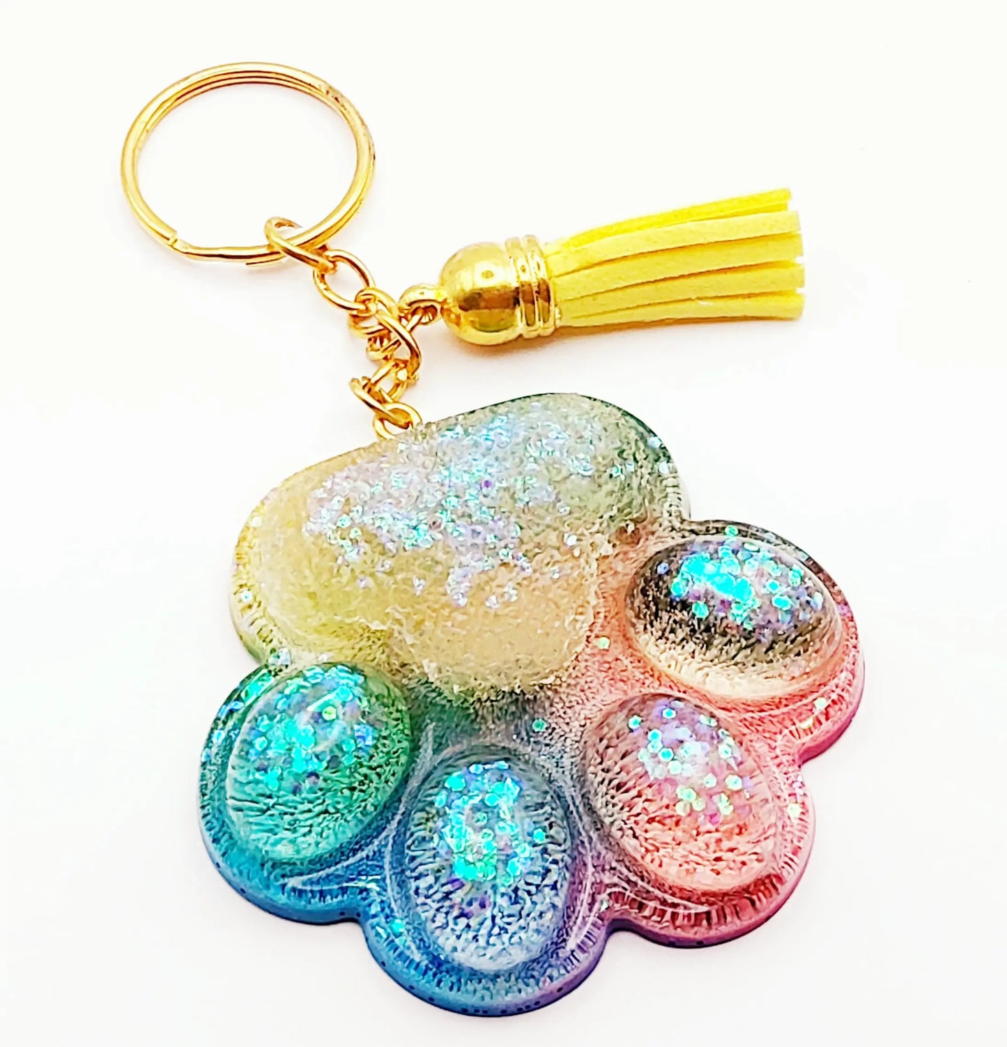 Porte-clés "Patte d'ours" en résine époxy. Multicolore, anneau doré, pompon gland jaune.