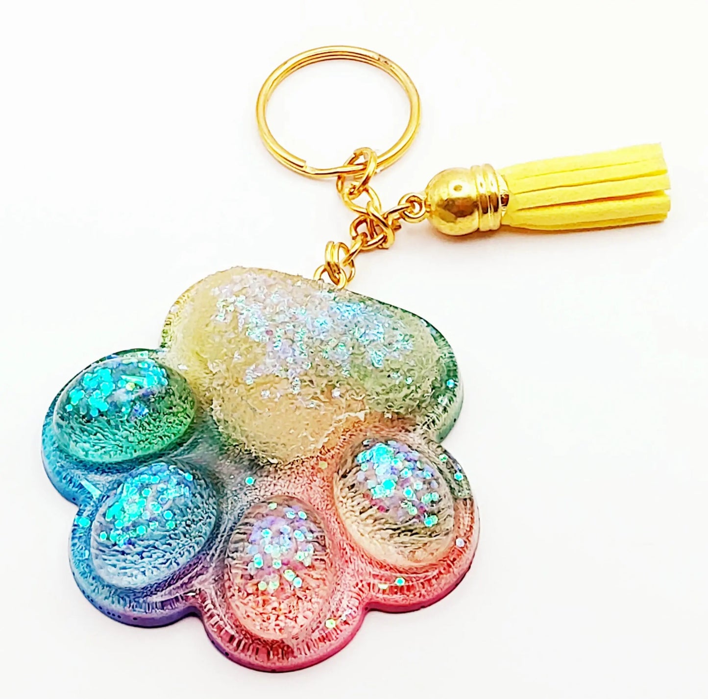 Porte-clés "Patte d'ours" en résine époxy. Multicolore, anneau doré, pompon gland jaune.