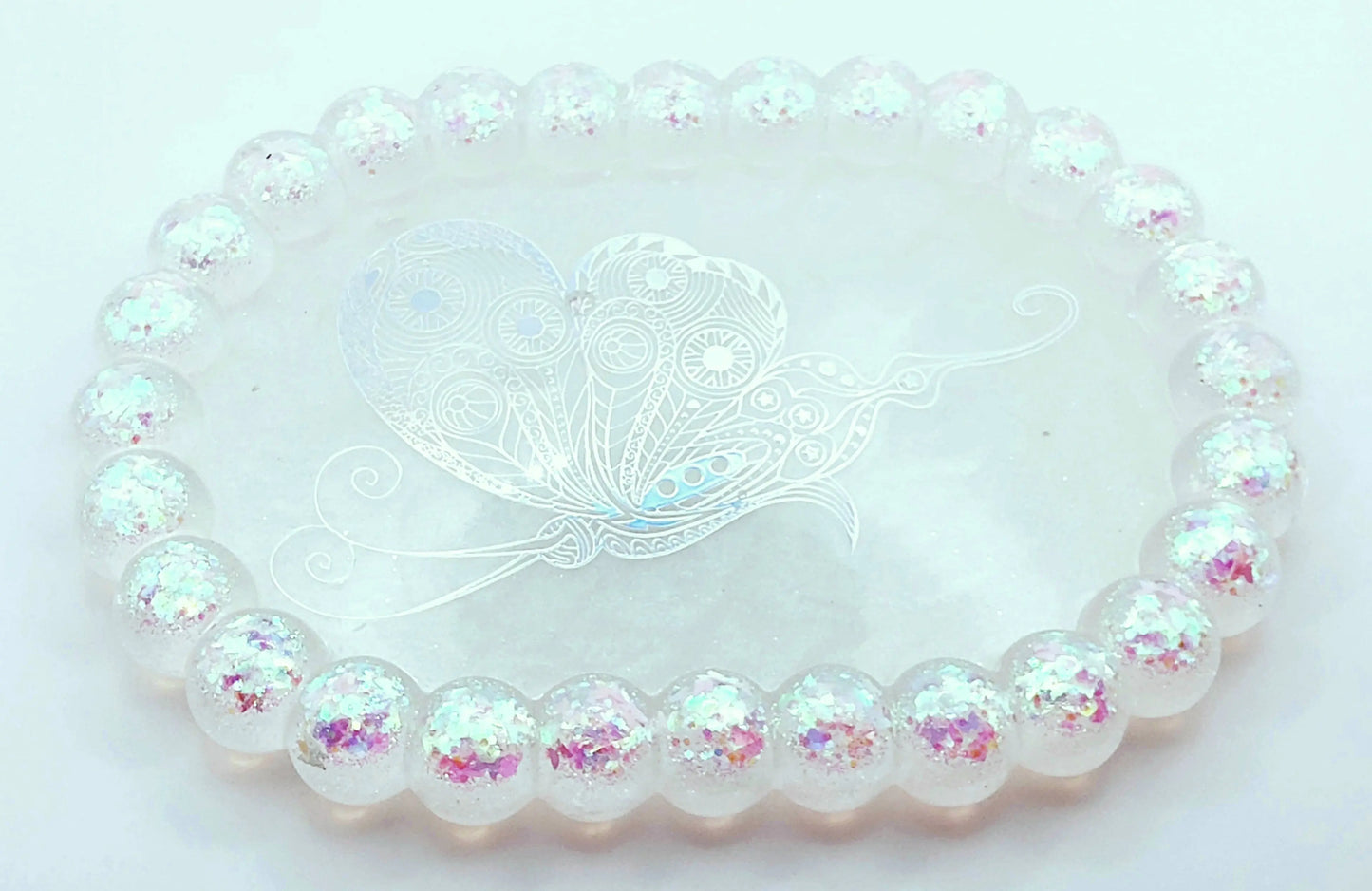 Vide-poches "Bulles" Ovale en résine époxy. Blanc, paillettes holographiques papillons en bordure. Grand papillon holographique au centre.
