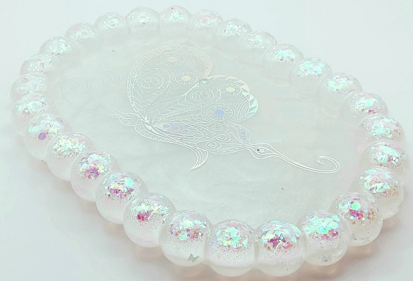 Vide-poches "Bulles" Ovale en résine époxy. Blanc, paillettes holographiques papillons en bordure. Grand papillon holographique au centre.
