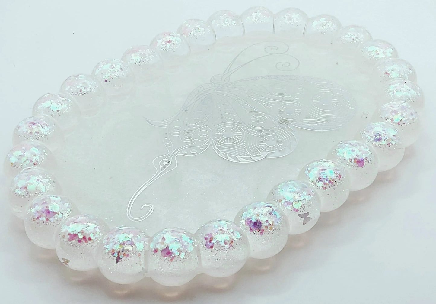 Vide-poches "Bulles" Ovale en résine époxy. Blanc, paillettes holographiques papillons en bordure. Grand papillon holographique au centre.