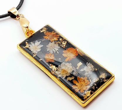 Pendentif Rectangulaire orné de fleurs séchées - Doré, fond noir, fleurs oranges et blanches - Cordon en coton ciré noir - PRETTY RESINE