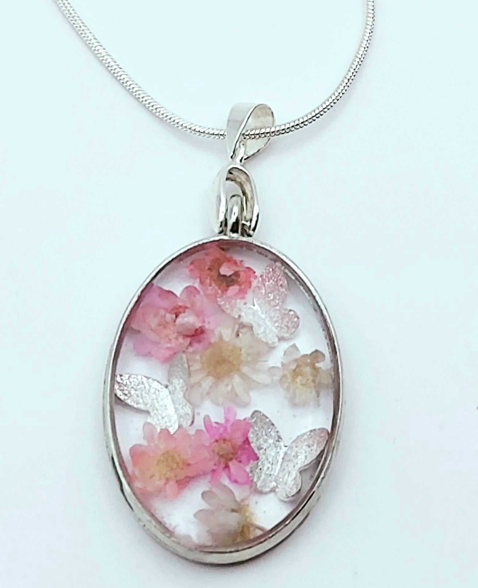 Pendentif Ovale orné de fleurs séchées roses et de papillons argentés - PRETTY RESINE