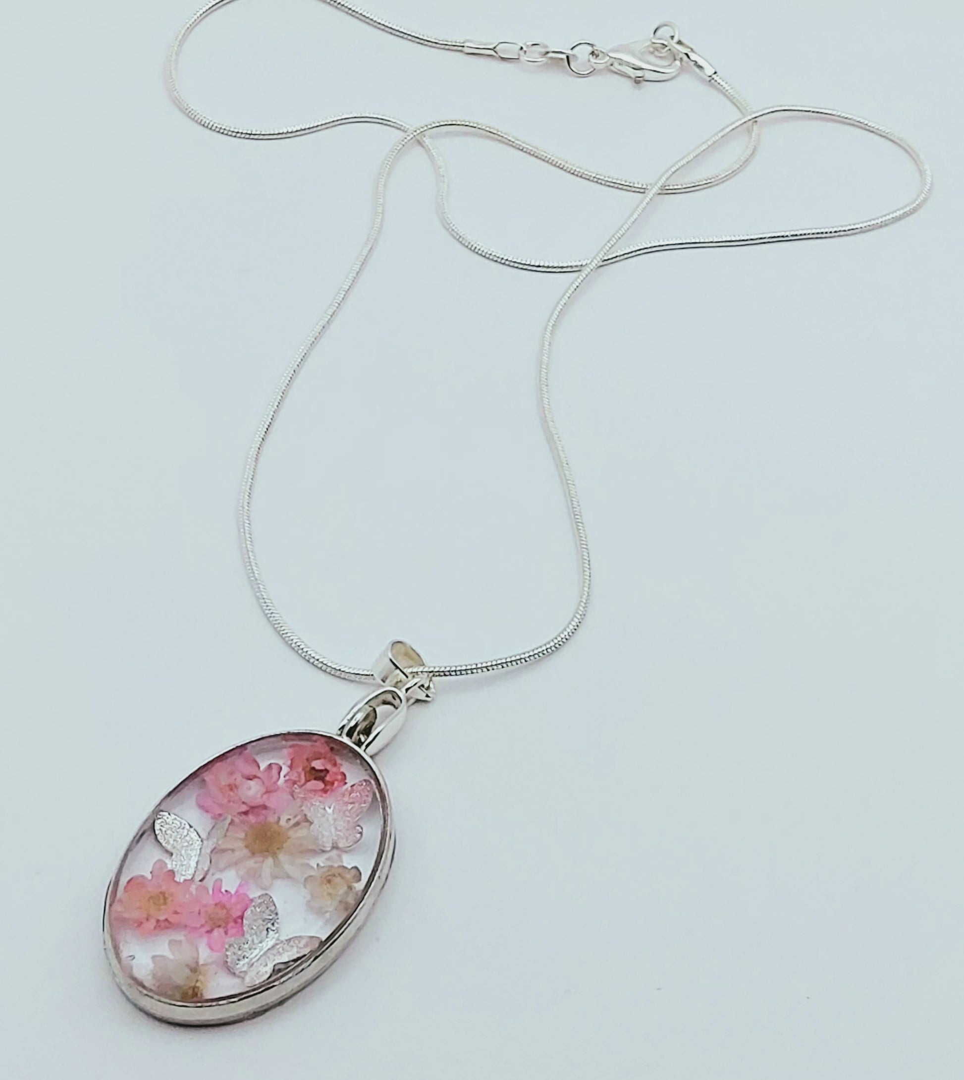 Pendentif Ovale orné de fleurs séchées roses et de papillons argentés - PRETTY RESINE