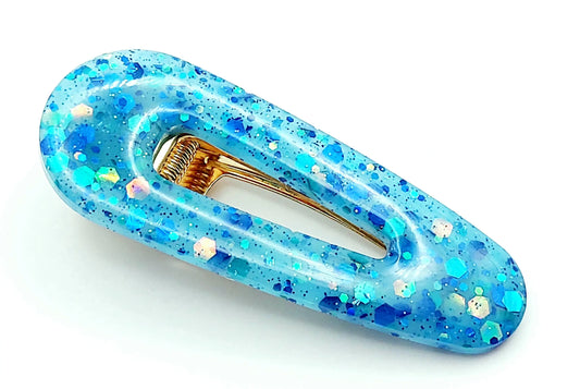 Barrette arrondie en résine époxy, bleu et paillettes holographiques.