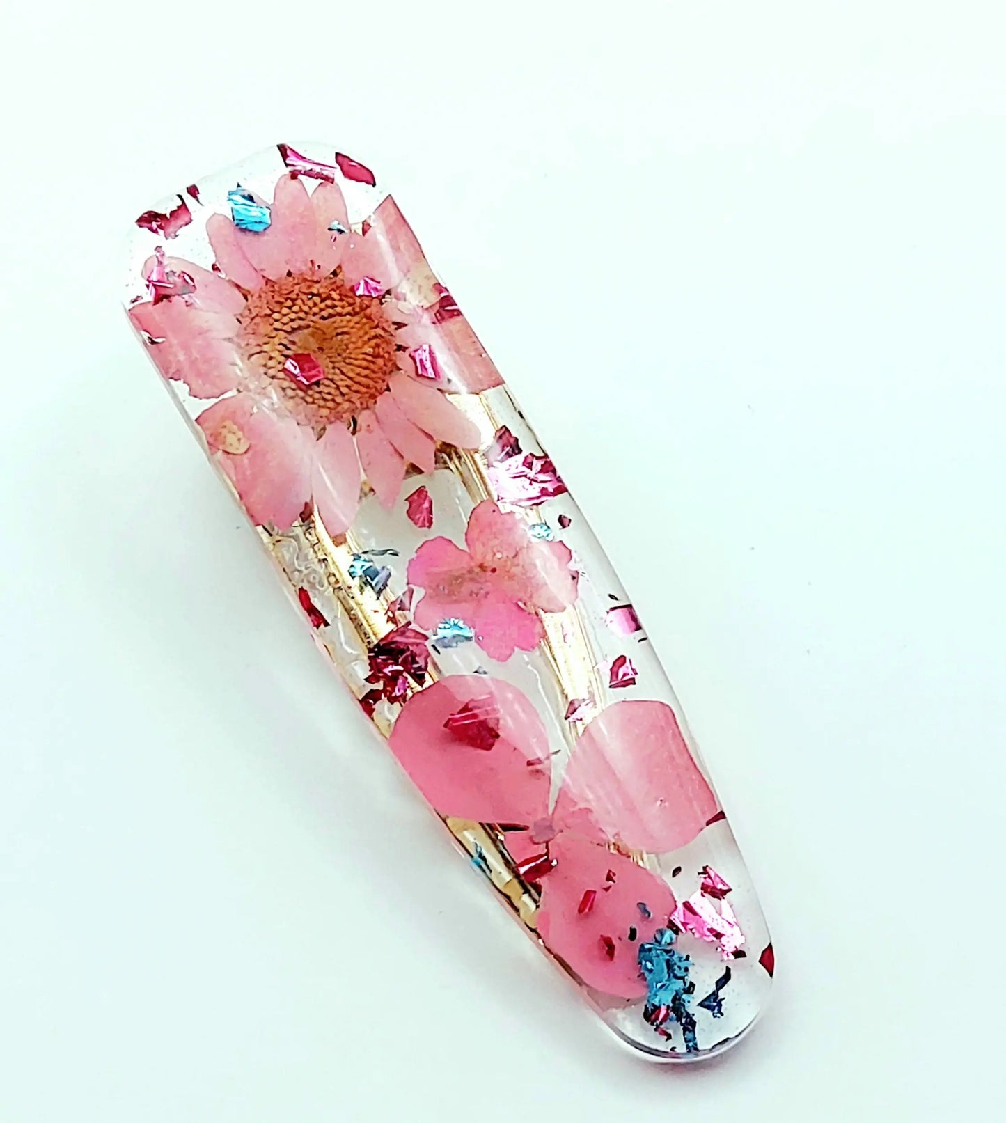 Barrette en résine époxy. Fleurs séchées roses. Feuille d'alu rose et bleu.