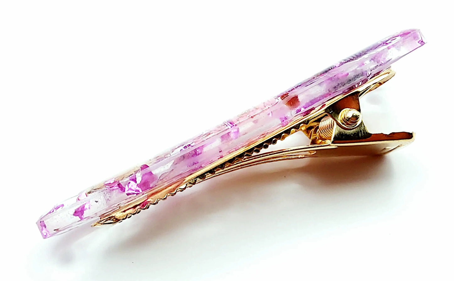 Barrette "arrondie" en résine époxy. Fleurs séchées rose et violettes. Vue de côté.