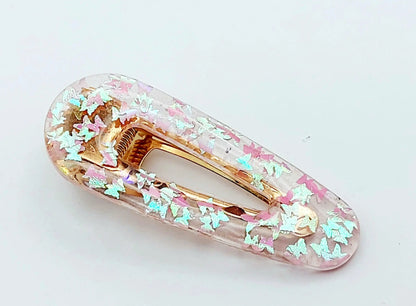 Barrette à cheveux "Arrondie" en résine époxy, paillettes papillons rose pâle.