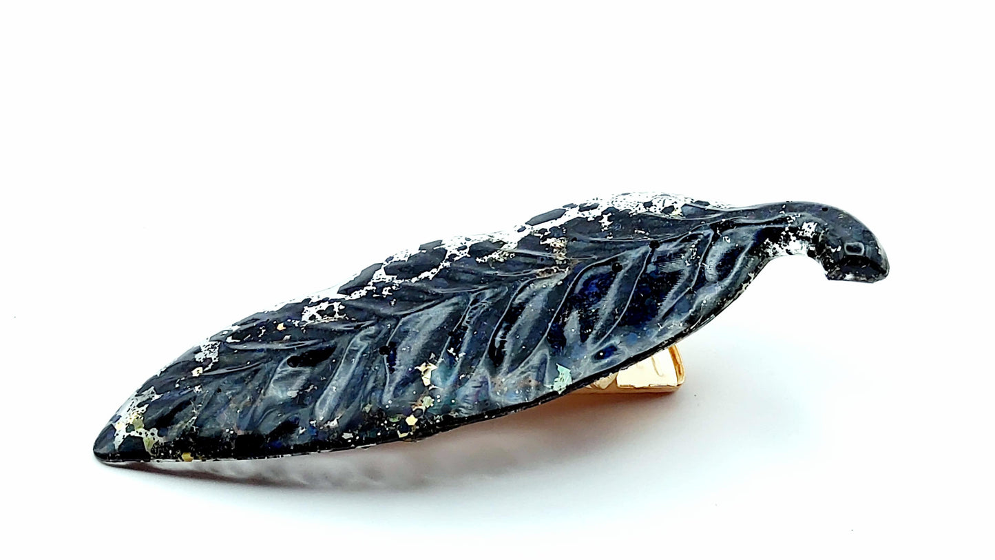 Barrette à cheveux "Feuille" en résine époxy, paillettes noires et dorées. Vue de côté.