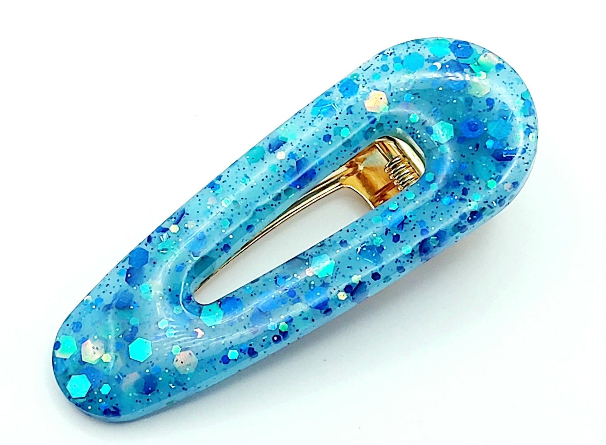 Barrette arrondie en résine époxy, bleu et paillettes holographiques.