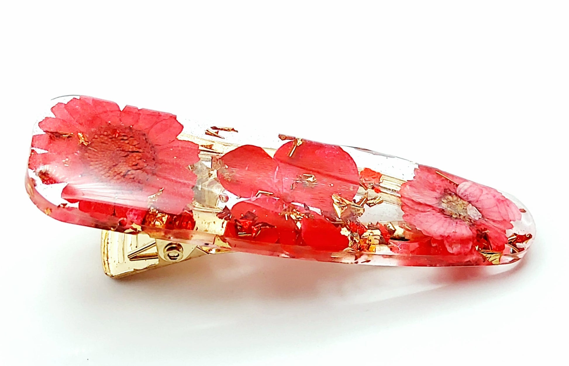 Barrette en résine époxy. Fleurs rouges et feuille d'or.