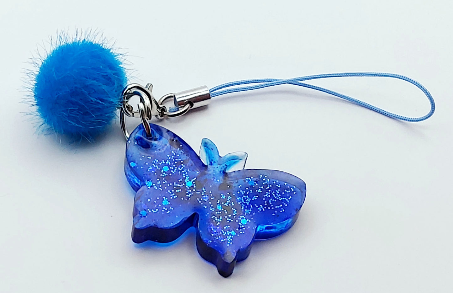 Bijou de téléphone Papillon en résine époxy - Bleu avec paillettes - Petit pompon bleu