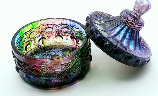 Boîte de rangement "Baroque" en résine époxy, multicolore et irisée. Couvercle posé de travers sur la boîte à droite.