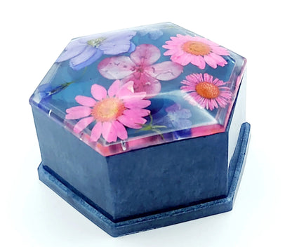 Boîte de rangement "Hexagone" en résine époxy. bleu et fleurs séchées naturelles roses et mauves. Fermée.