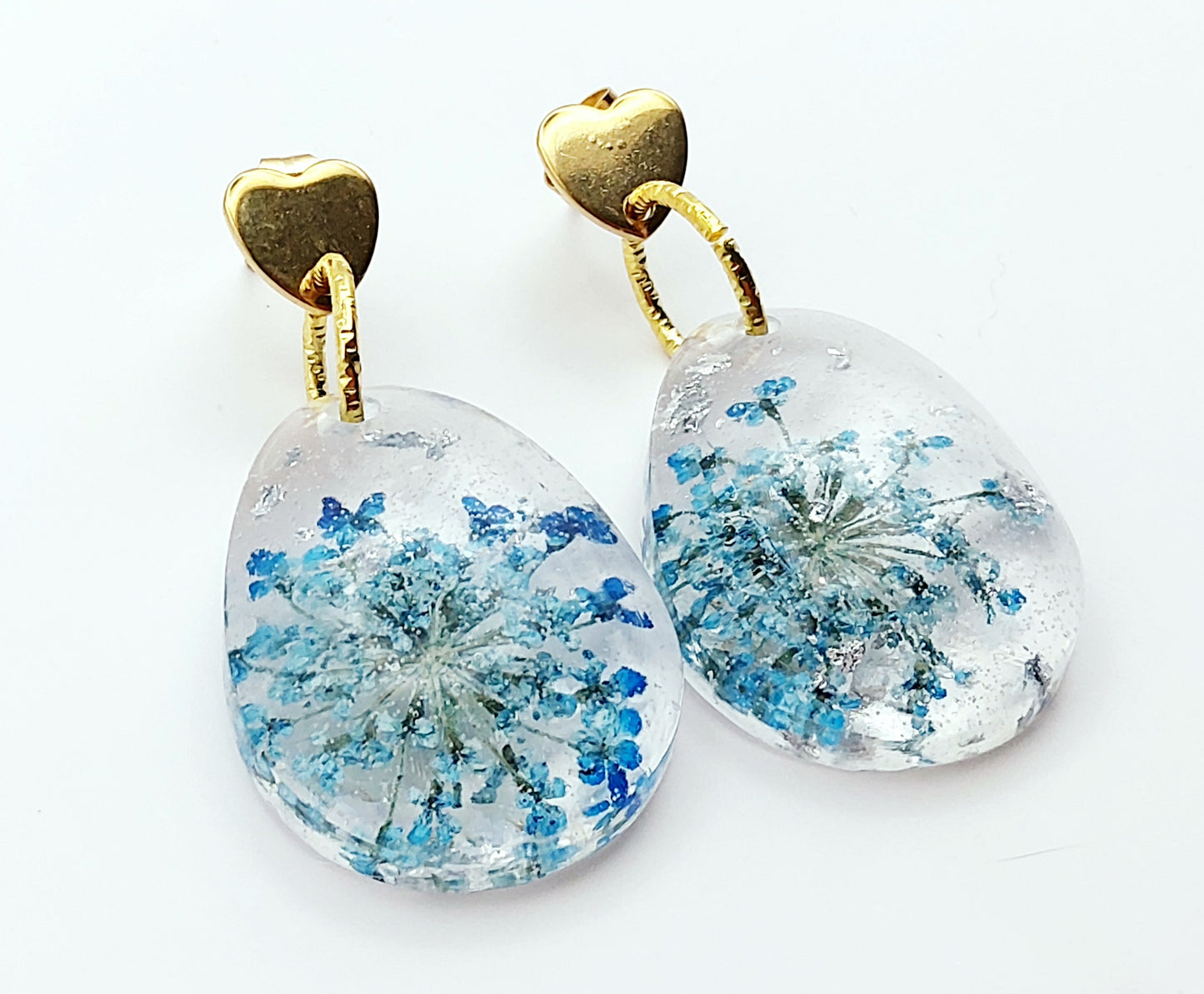 Boucles d'oreilles en résine "Fleur bleue dans une goutte d'eau", avec feuille d'argent, apprêts en forme de coeur